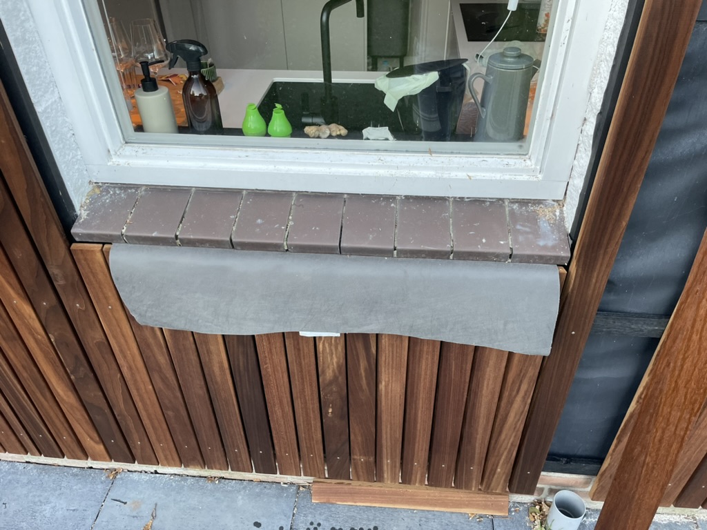 Plastisol vensterbank wordt tijdens montage over oude tegels geplaatst